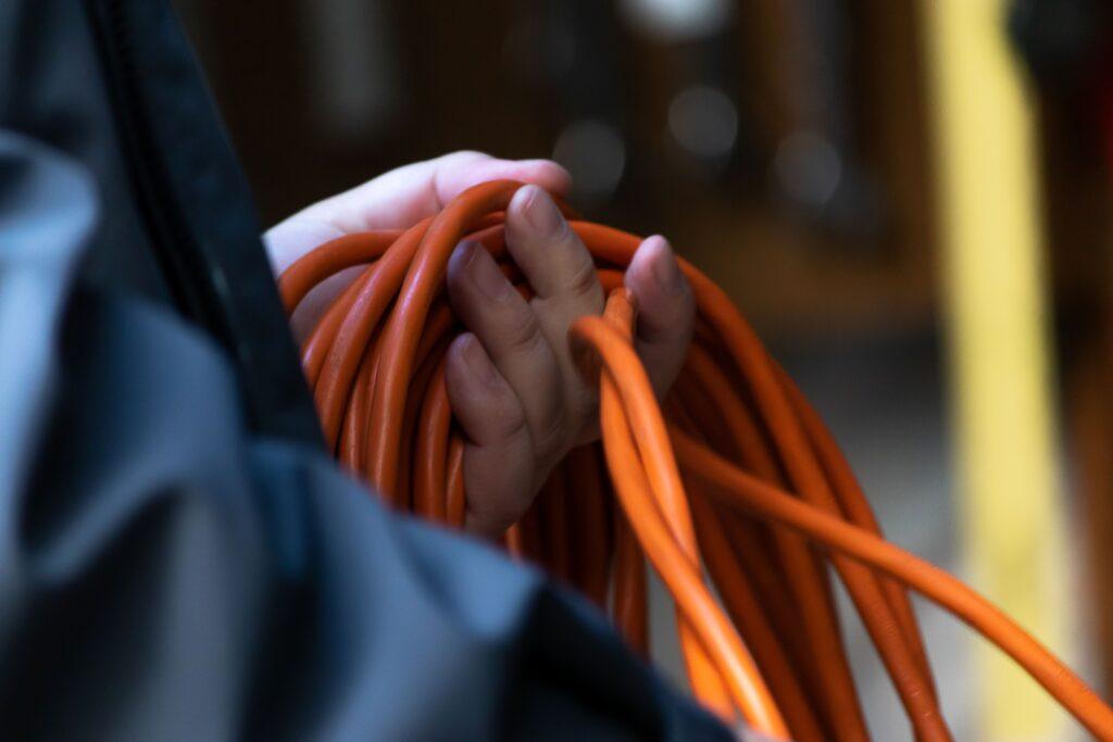 Techniker hält orangefarbenes Kabelbündel – Symbolbild für individuelle Kabelkonfektionierung in der Industrie