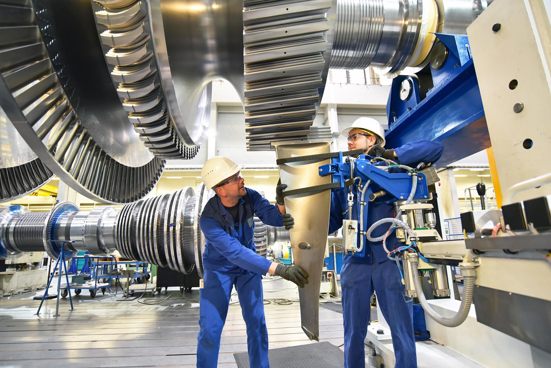 Arbeiter montieren Komponenten an einer Industrieanlage | Spannrolle für Keilriemen